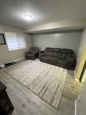 Living room with a textured ceiling and light wood-type flooring