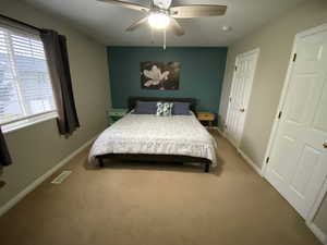 Carpeted bedroom featuring ceiling fan