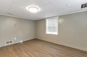 Unfurnished room featuring ornamental molding and light hardwood / wood-style floors