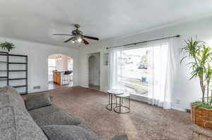 Carpeted living room with ceiling fan