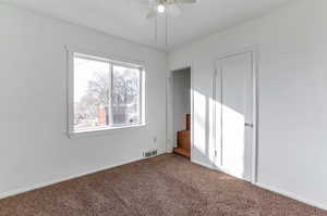 Empty room with ceiling fan and carpet flooring