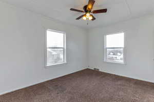 Unfurnished room featuring crown molding, ceiling fan, a healthy amount of sunlight, and carpet floors