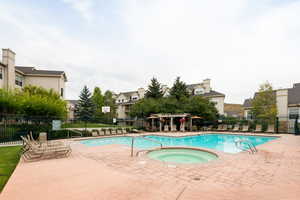 View of swimming pool featuring a community hot tub, a pergola, and a patio