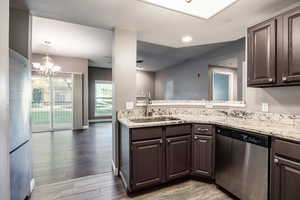 Kitchen featuring dark brown cabinetry, sink, hardwood / wood-style flooring, and appliances with stainless steel finishes