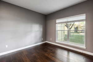 Empty room with dark hardwood / wood-style flooring