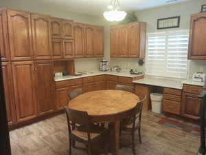 Kitchen featuring hanging light fixtures, light stone counters, and light hardwood / wood-style flooring