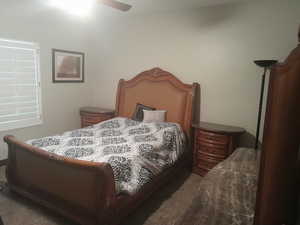 Carpeted bedroom featuring ceiling fan