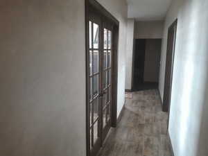 Corridor with dark wood-type flooring and french doors