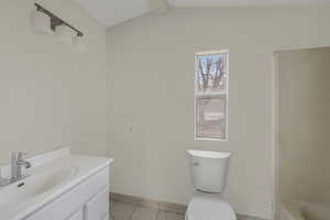 Bathroom featuring lofted ceiling with beams, vanity, and toilet