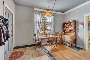 Dining space featuring ornamental molding and light hardwood / wood-style flooring