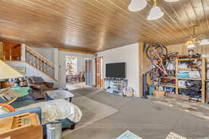 Carpeted living room featuring wooden ceiling