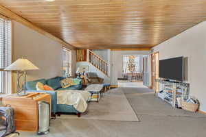 Carpeted living room with a healthy amount of sunlight and wood ceiling