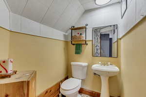 Bathroom with lofted ceiling, sink, and toilet