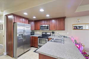 Kitchen with stainless steel appliances, kitchen peninsula, and sink