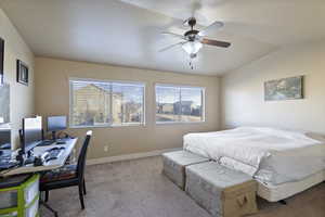 Bedroom featuring ceiling fan, light colored carpet, and vaulted ceiling