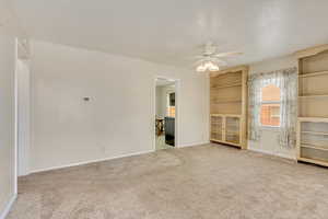 Carpeted empty room with ceiling fan