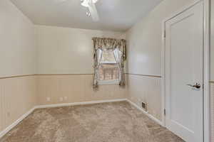 Spare room with ceiling fan and light colored carpet