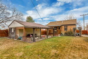 Back of property with a patio and a lawn