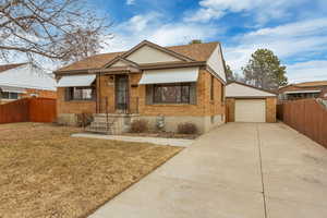 Bungalow-style home featuring an outbuilding, a garage, and a front yard