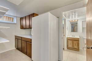 Kitchen with sink, light tile patterned floors, and a textured ceiling