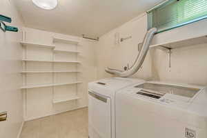 Laundry room featuring light tile patterned floors and independent washer and dryer