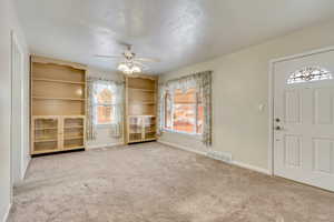 Carpeted foyer with ceiling fan