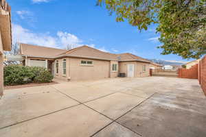 Back of property featuring a mountain view, central AC unit, and a patio area