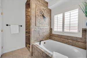 Bathroom with independent shower and bath and tile patterned floors