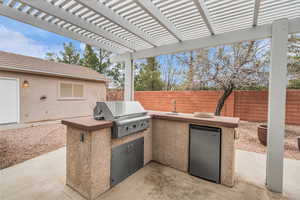 View of patio / terrace with exterior kitchen, area for grilling, sink, and a pergola