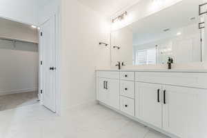Full bath with a shower stall, marble finish floor, visible vents, baseboards, and a spacious closet