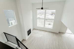 Unfurnished living room featuring baseboards, wood finished floors, and a glass covered fireplace