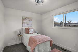 Bedroom featuring dark colored carpet