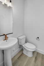 Bathroom with hardwood / wood-style flooring and toilet