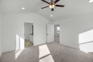 Unfurnished bedroom with vaulted ceiling and light colored carpet