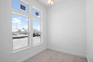 Unfurnished room with a healthy amount of sunlight and light colored carpet