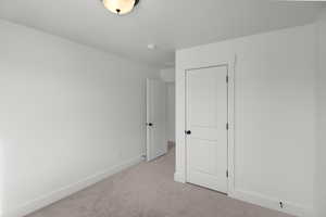 Unfurnished bedroom with light colored carpet