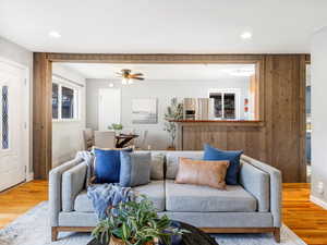 Open concept living room with hardwood / wood-style floors and ceiling fan