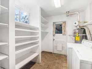 Laundry area with independent washer and dryer and strapped water heater, and a doggie door.