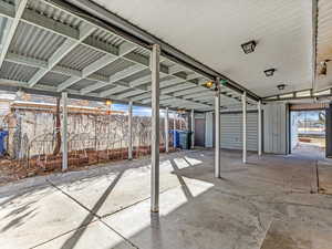 Covered patio, garage, outdoor living space leading into backyard.