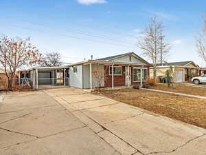 View of front facade with a garage, a carport and RV parking with a swing gate!