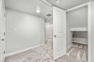 Interior space with light colored carpet and a textured ceiling