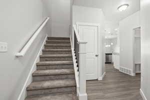 Stairs with hardwood / wood-style flooring and sink