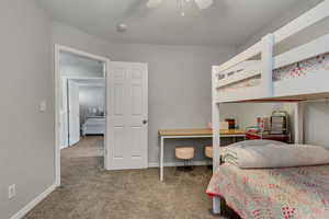 Carpeted bedroom featuring ceiling fan