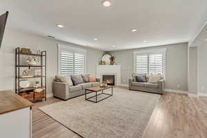 Living room featuring a tile fireplace, a textured ceiling, and light wood-type flooring