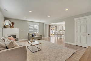 Living room featuring a tiled fireplace and light wood-type flooring