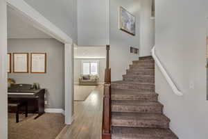 Staircase with hardwood / wood-style floors and a high ceiling