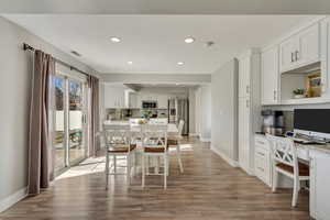 Dining area featuring wood-type flooring, sink, and built in desk