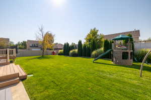 View of yard featuring a playground and a deck