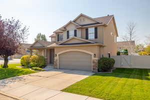 Craftsman inspired home with a garage and a front lawn