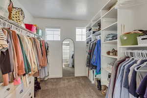 Walk in closet featuring dark carpet